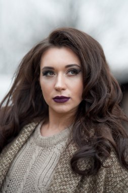 Bahar country tarzında. Beyaz örgü kazak ve kürklü şapka ayakta house, giyen kazak rahat yakınındaki bahçedeki rustik ahşap duvar önünde genç kadın portresi tam uzunlukta.