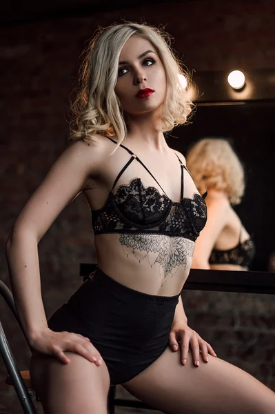 Beautiful fashion model sexy and passhionate blonde woman with red lips posing near the mirror wearing black sexy lingerie — Φωτογραφία Αρχείου