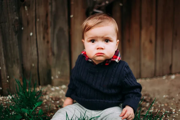 Lindo menino sentado na grama verde, 9months at the wood background — Fotografia de Stock