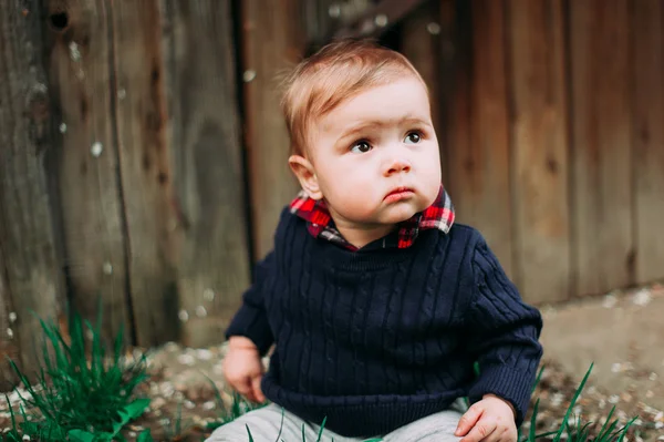 Lindo menino sentado na grama verde, 9months at the wood background — Fotografia de Stock