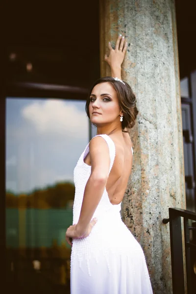 Bella sposa bruna sexy in abito bianco che sale le scale — Foto Stock