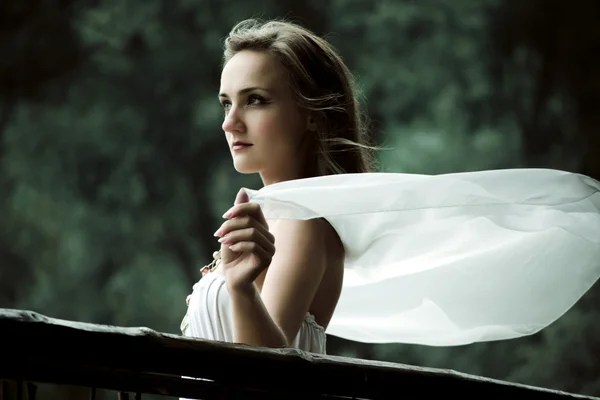 Uma mulher bonita. Jovem mulher bonita vestindo um vestido branco em um p — Fotografia de Stock