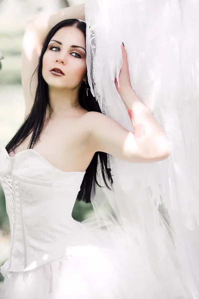 Portret van dark-haired jongedame in de bloemrijke tuin in th — Stockfoto