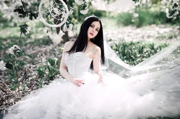 Retrato de jovem mulher de cabelos escuros no jardim florido em th — Fotografia de Stock