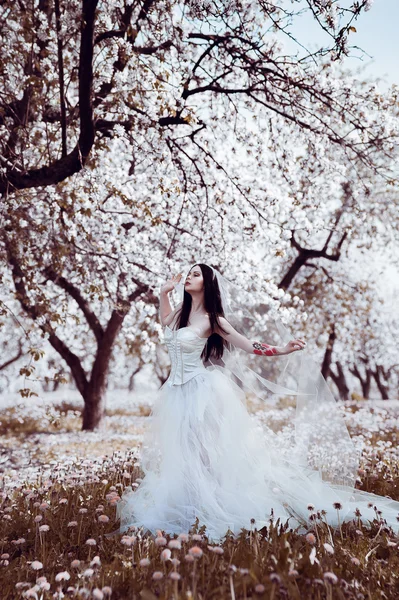 Retrato de jovem mulher de cabelos escuros no jardim florido em th — Fotografia de Stock