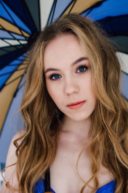 Zarif mavi külot ve sutyen güzel seksi Bayan. Moda portre modelinin kapalı. Bir şemsiye tutan güzellik sarışın kadın. Yüzünü kapat. Düzeltisiz atış