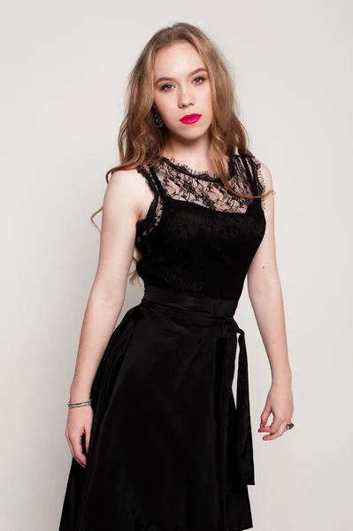 Portrait of beautiful young blonde girl in black dress. Fashion photo — Stock Photo, Image