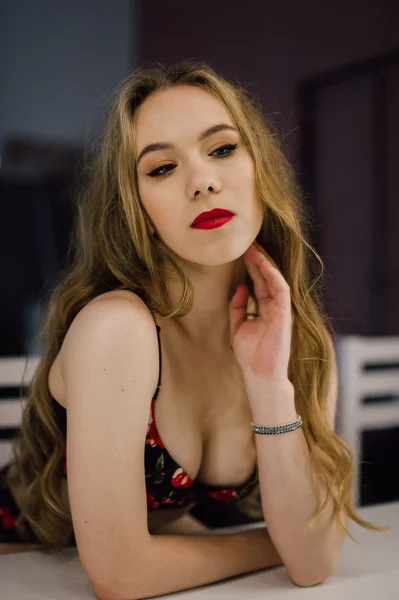Young beautiful woman applying her make up face with brush, looking in a mirror, sitting on chair at dressing room with vintage mirror dark room, wearing red lingerie — Stock Photo, Image