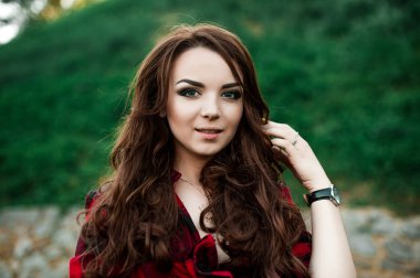 Poz ve kentsel duvar arka planda kırmızı kareli gömlek, şort, açık havada yaz portre yakınındaki gülümseyen güzel genç hippi kız.