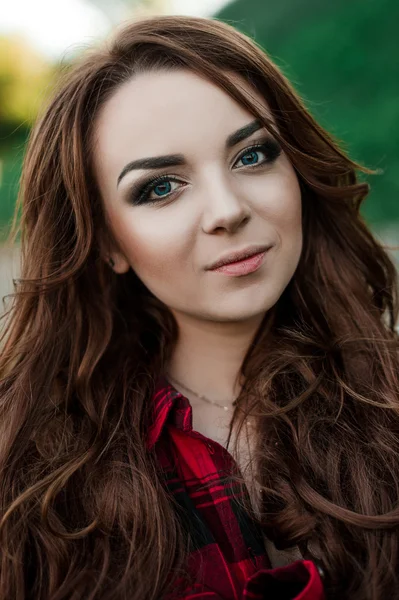 Gyönyörű fiatal csípő lány jelentő és mosolyogva közelében városi háttér piros kockás ing, nadrág, szabadban nyári portré. — Stock Fotó