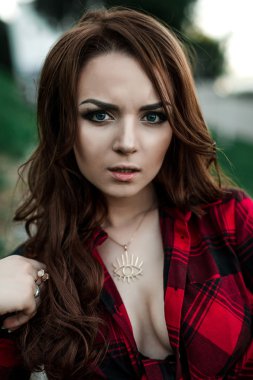 Poz ve kentsel duvar arka planda kırmızı kareli gömlek, şort, açık havada yaz portre yakınındaki gülümseyen güzel genç hippi kız.