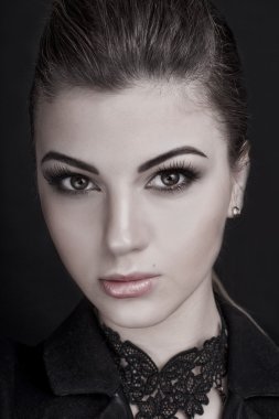 Profesyonel makyaj ile güzel kadın koyu arka plan üzerinde ceket giyiyor makyaj. Saç modeli, stüdyo çekimi