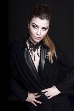 Profesyonel makyaj ile güzel kadın koyu arka plan üzerinde ceket giyiyor makyaj. Saç modeli, stüdyo çekimi