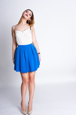 Parlak pozitif moda studio mor dudaklar, parlak makyaj, seksi vücut, şık moda kıyafet ile genç ve güzel kız portresi: mavi etek, akıllı rahat, güzel duygular, renk pop, beyaz arka plan.