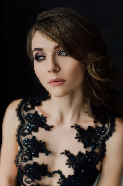 Close-up. Individualiteit. Doordachte elegante dame in zwarte Prom avondjurk. Studio geretoucheerde foto. — Stockfoto