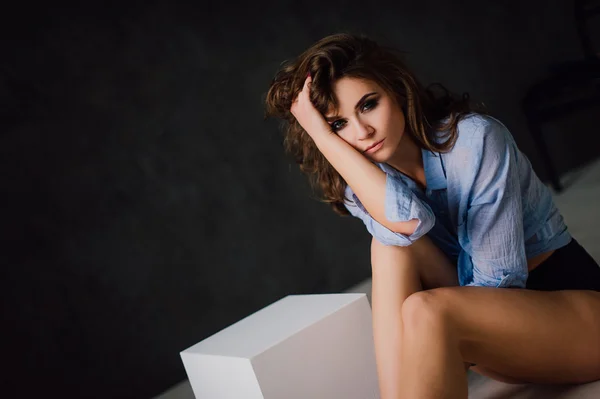 Retrato de mulher sexy jovem positivo posando em estúdio em luz natural, vestindo camisa azul, tem bom e saudável ajuste. Estúdio retocado tiro . — Fotografia de Stock