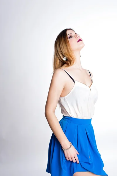 Φωτεινά θετική μόδα στούντιο πορτρέτο της όμορφο νεαρό κορίτσι με μωβ χείλη, φωτεινό μακιγιάζ, σέξι σώμα, κομψό και μοντέρνο ντύσιμο: μπλε φούστα, smart casual, χαριτωμένο συναισθήματα, ποπ χρώμα, λευκό φόντο. — Φωτογραφία Αρχείου