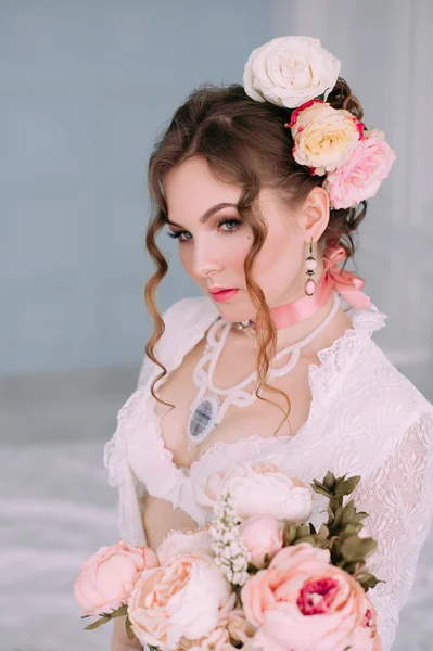 Beautiful young sexy woman , wearing white lingerie, room decorated with flowers. Perfect makeup. Beauty fashion. Eyelashes. Studio retouched shot. — Stock Photo, Image