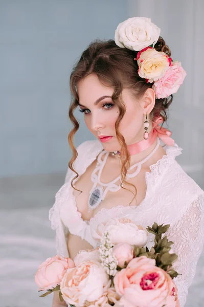 Belle jeune femme sexy, vêtue de lingerie blanche, chambre décorée de fleurs. Maquillage parfait. Mode beauté. Des cils. Studio retouché . — Photo