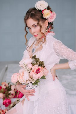 Beyaz iç çamaşırı, Oda giyen güzel genç seksi kadın çiçeklerle süslenmiş. Mükemmel makyaj. Güzellik moda. Kirpik. Stüdyo düzeltisiz atış. 
