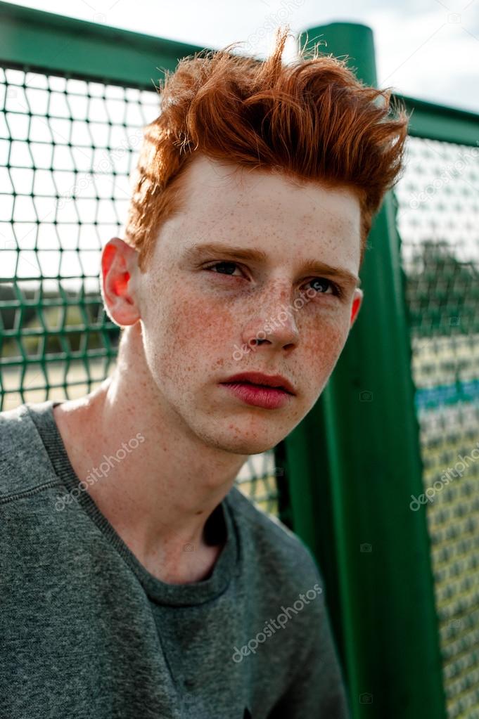 One young handsome red haired fashionable boy standing near stadium in sunny day outdoor , wearing casual clothing Stock Photo by © 119248826 One young handsome red haired fashionable boy standing near stadium in sunny day outdoor , wearing casual clothing Stock Photo by © 119248826