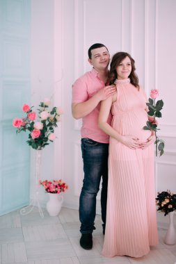 Bebeğin doğumu için bekleyen ailen. Hamile bir kadın ve kocası giyen beyaz giyim