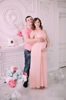 Bebeğin doğumu için bekleyen ailen. Hamile bir kadın ve kocası giyen beyaz giyim