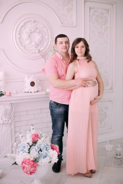 Bebeğin doğumu için bekleyen ailen. Hamile bir kadın ve kocası giyen beyaz giyim