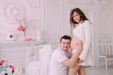 Bebeğin doğumu için bekleyen ailen. Hamile bir kadın ve kocası giyen beyaz giyim