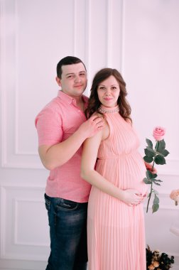 Bebeğin doğumu için bekleyen ailen. Hamile bir kadın ve kocası giyen beyaz giyim