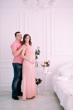 Bebeğin doğumu için bekleyen ailen. Hamile bir kadın ve kocası giyen beyaz giyim