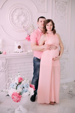 Bebeğin doğumu için bekleyen ailen. Hamile bir kadın ve kocası giyen beyaz giyim