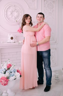 Bebeğin doğumu için bekleyen ailen. Hamile bir kadın ve kocası giyen beyaz giyim