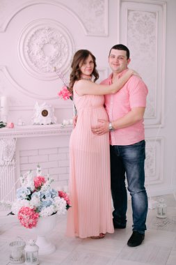 Bebeğin doğumu için bekleyen ailen. Hamile bir kadın ve kocası giyen beyaz giyim