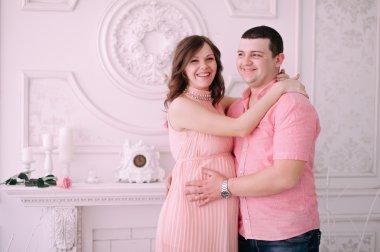 Bebeğin doğumu için bekleyen ailen. Hamile bir kadın ve kocası giyen beyaz giyim