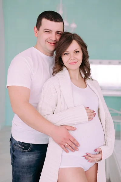 Famiglia in attesa della nascita del bambino. Una donna incinta e suo marito indossano abiti bianchi — Foto Stock