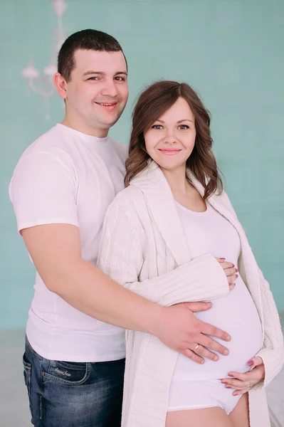 Famille attendant la naissance du bébé. Une femme enceinte et son mari portant des vêtements blancs — Photo