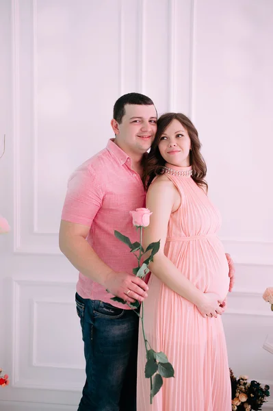 Οικογένεια περιμένοντας την γέννηση του μωρού. Μια έγκυος γυναίκα και ο σύζυγός της φορώντας λευκά ρούχα — Φωτογραφία Αρχείου