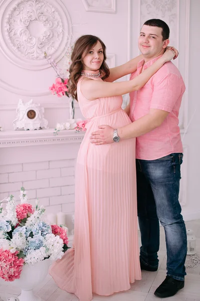 Family waiting for baby\'s birth. A pregnant woman and her husband wearing white clothing