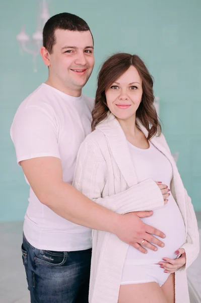 Rodzina czeka na narodziny dziecka. Kobiety w ciąży i jej mąż noszenia białych ubrań — Zdjęcie stockowe
