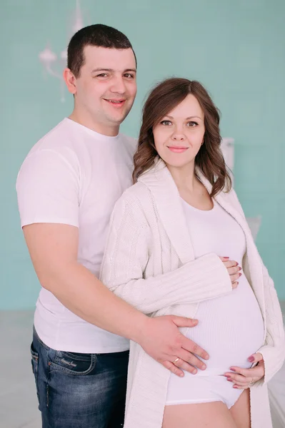 Famille attendant la naissance du bébé. Une femme enceinte et son mari portant des vêtements blancs — Photo