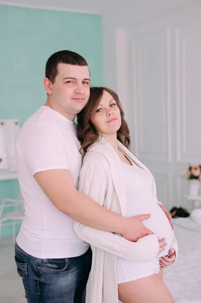 Familie wachten op de geboorte van baby. Een zwangere vrouw en haar echtgenoot dragen witte kleding — Stockfoto