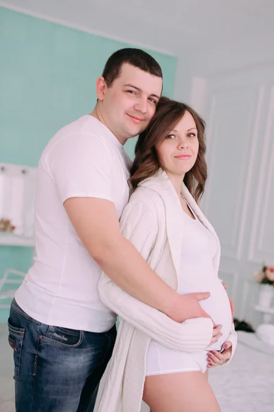 Family waiting for baby\'s birth. A pregnant woman and her husband wearing white clothing