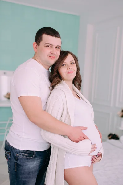 Famille attendant la naissance du bébé. Une femme enceinte et son mari portant des vêtements blancs — Photo