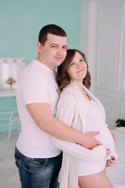 Familie wachten op de geboorte van baby. Een zwangere vrouw en haar echtgenoot dragen witte kleding — Stockfoto