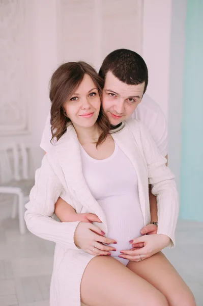 Keluarga menunggu kelahiran bayi. Seorang wanita hamil dan suaminya mengenakan pakaian putih — Stok Foto