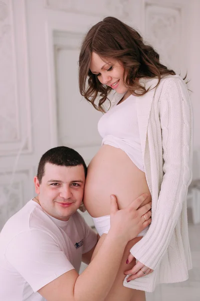 Familia esperando el nacimiento del bebé. Una mujer embarazada y su marido con ropa blanca —  Fotos de Stock