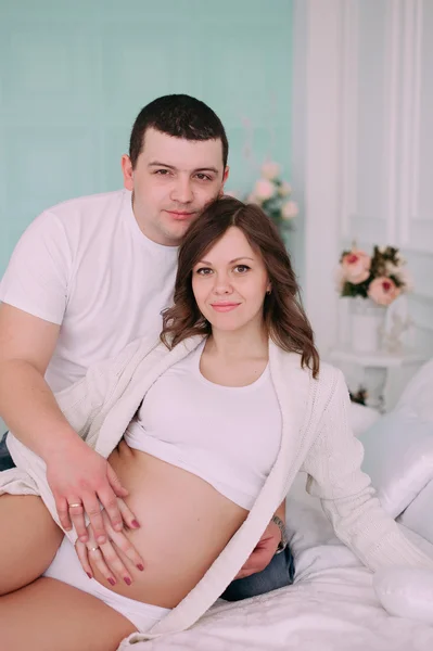 Famille attendant la naissance du bébé. Une femme enceinte et son mari portant des vêtements blancs — Photo