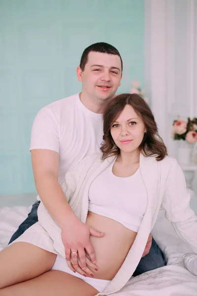 Family waiting for baby's birth. A pregnant woman and her husband wearing white clothing — Stock Photo, Image