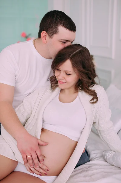 Familie wartet auf die Geburt des Babys. eine schwangere Frau und ihr Mann tragen weiße Kleidung — Stockfoto